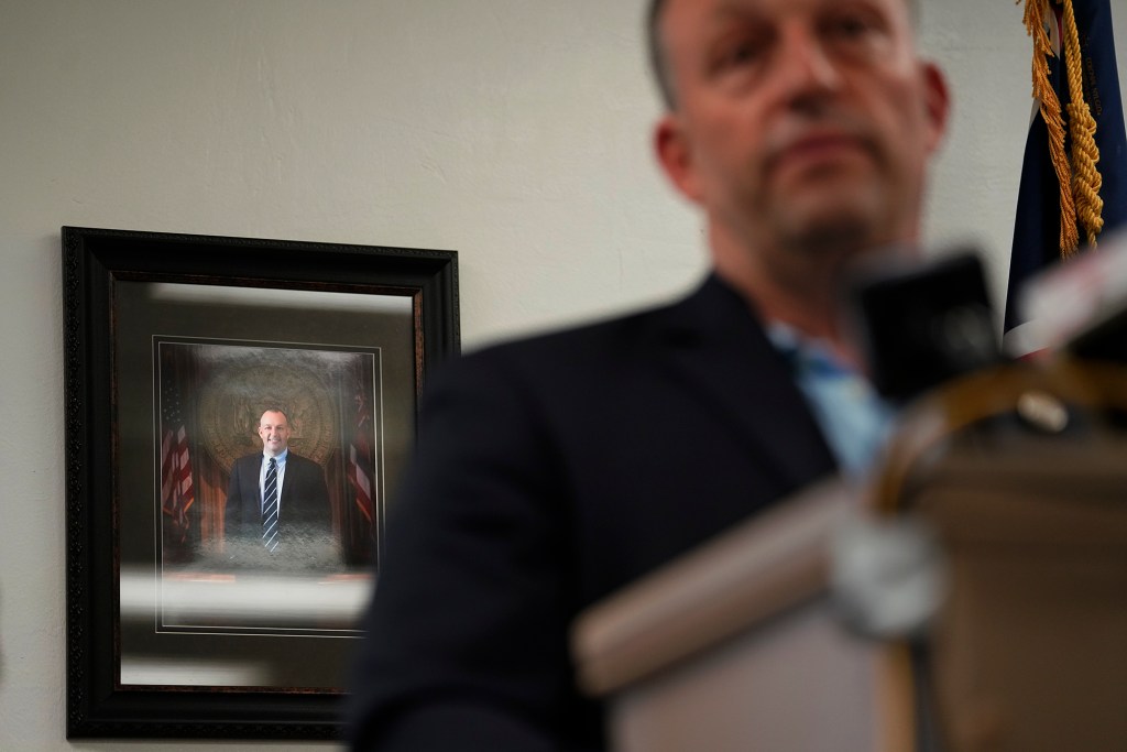 A portrait of Gov. Josh Green hangs on the wall behind the governor during a press conference Wednesday, Oct. 18, 2023, in Wailuku. Federal, state and county governments gave updates on progress after the Aug. 8 fire which destroyed Lahaina town and Kula area. (Kevin Fujii/Civil Beat/2023)