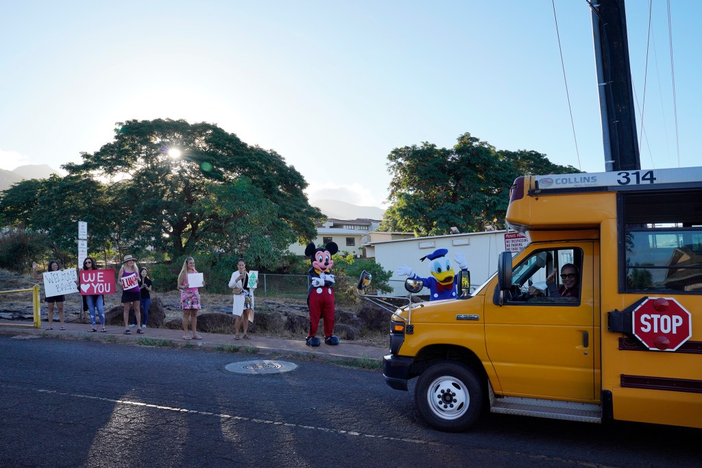 Supporters welcome elementary school students back to a West Maui campus Wednesday, Oct. 18, 2023, in Lahaina. Princess Nahienaena Elementary School opened their campus for King Kamehameha III Elementary School to place temporary buildings. The schools have been closed since the Aug. 8 fire and studying at other schools in Maui. King Kamehameha III Elementary School was destroyed in the blaze. (Kevin Fujii/Civil Beat/2023)