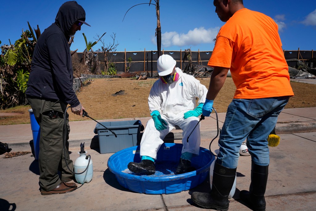 Workers spraying down burned buildings in Lahaina had to exercise extreme caution to avoid contact with the soil stabilizer in its liquid form. (Kevin Fujii/Civil Beat/2023)