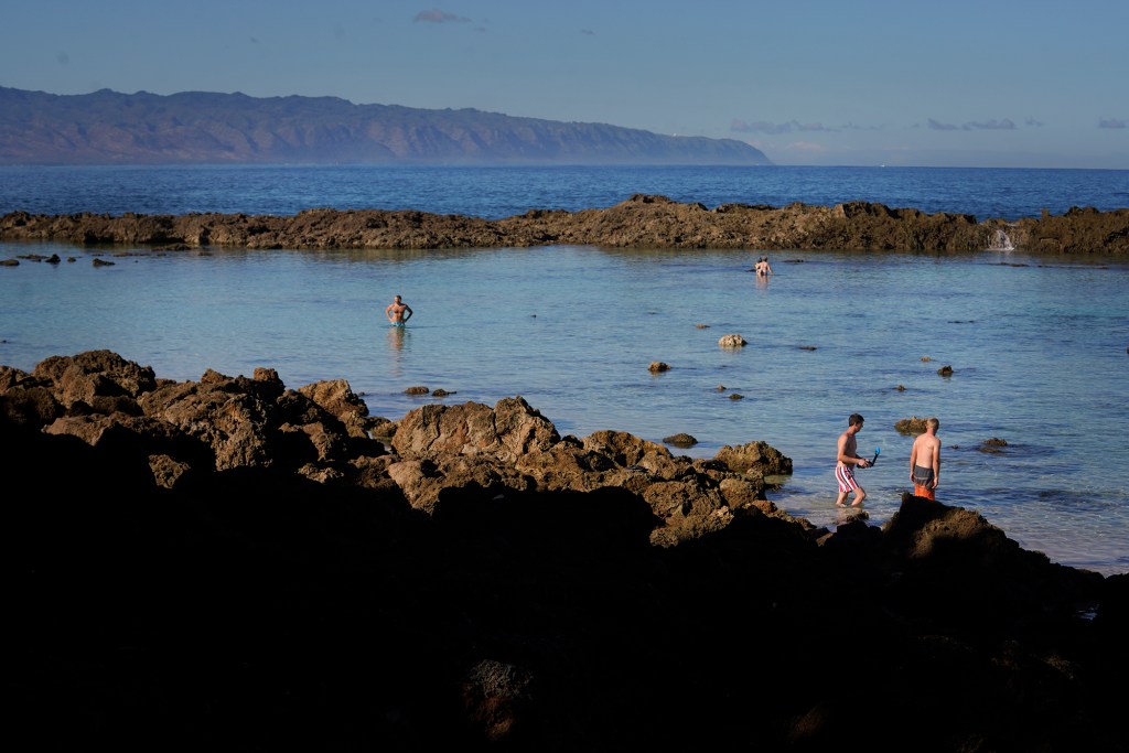 Tourists and snorkelers enjoy Sharks Cove Thursday, Nov. 2, 2023, in Haleiwa. A new housing development at the already crowded beach and snorkeling spot on the North Shore would create more crowds if the homes are used as short-term rentals for tourists. (Kevin Fujii/Civil Beat/2023)