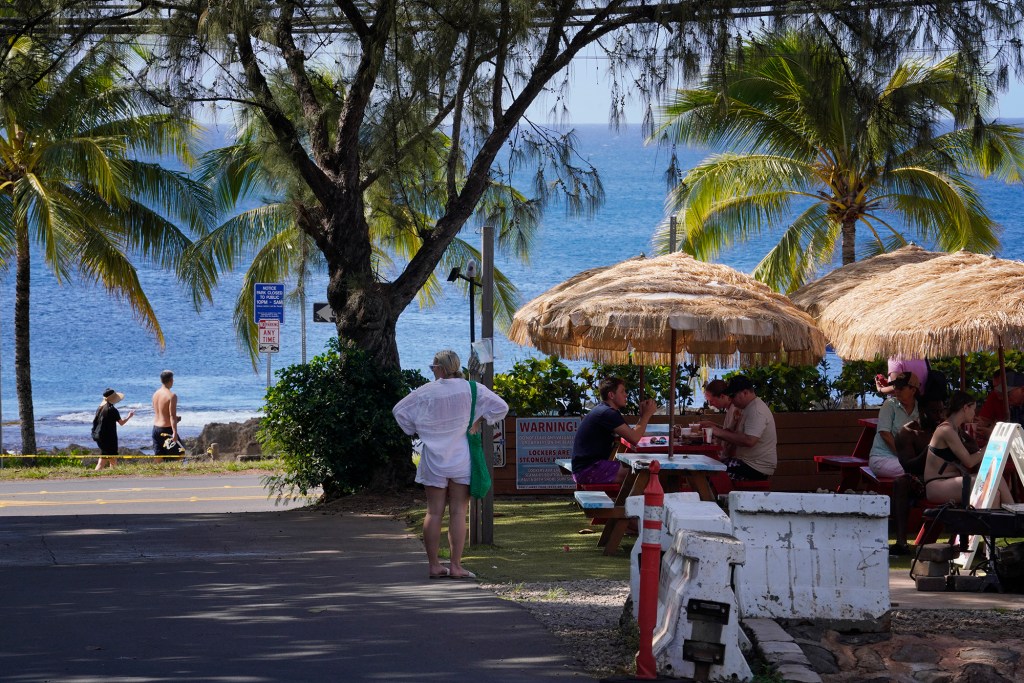 An area mauka of Sharks Cove with food trucks and water sports for tourist is photographed Wednesday, Nov. 8, 2023, in Haleiwa. The businesses here will struggle with proposed development taking over the area. (Kevin Fujii/Civil Beat/2023)