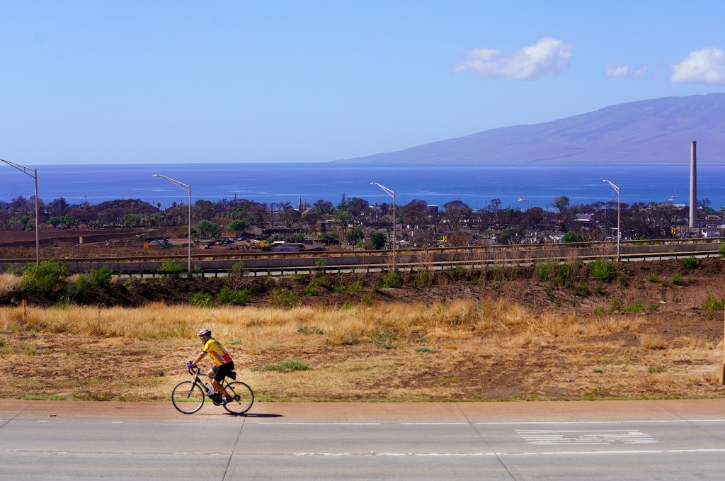 A cyclist rides the Lahaina Bypass mauka of Lahaina town Thursday, Nov. 9, 2023. Lahaina town was devastated by the Aug. 8. fire. Tourism reopened in West Maui on Nov. 1. (Kevin Fujii/Civil Beat/2023)