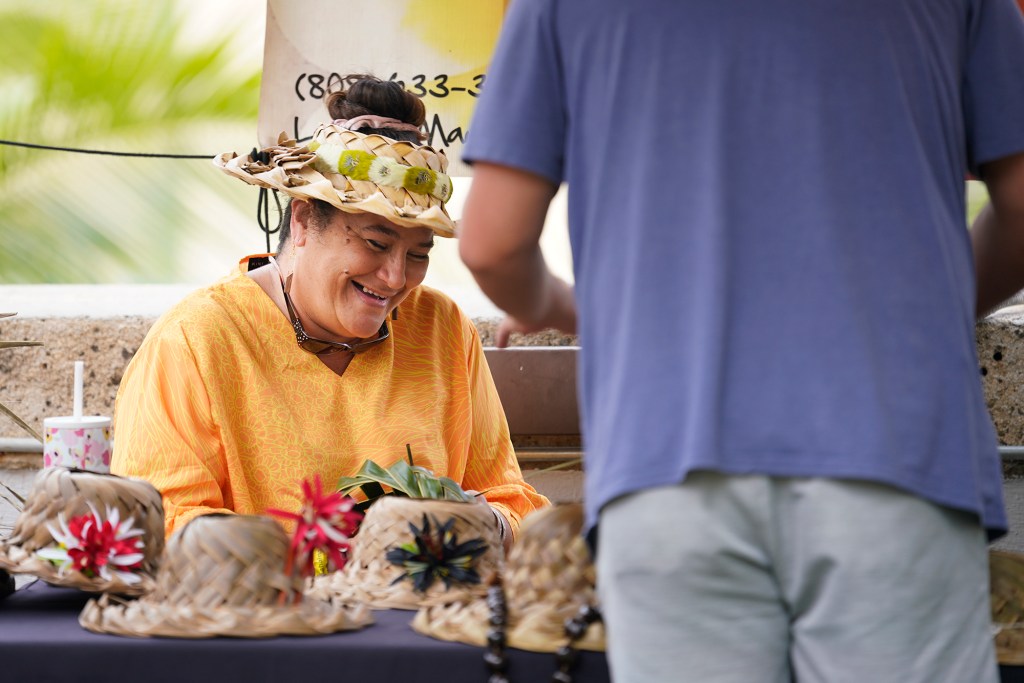 U’i Kahue-Cabanting laughs with a friend who stopped by her booth Monday, Nov. 20, 2023, in Honolulu. Monday, Kahue-Cabanting set up a booth at Kokua for Maui at the Royal Hawaiian Shopping Center. (Kevin Fujii/Civil Beat/2023)
