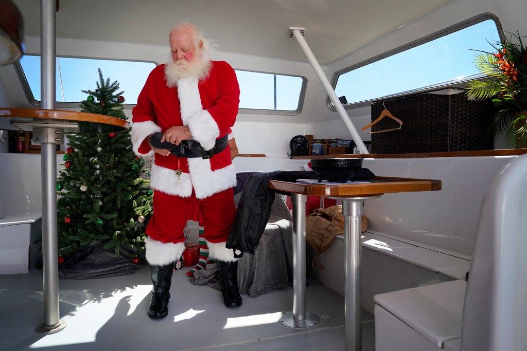 Ron Proctor dresses for his duties on the Alii Nui Sunset Sail Santa Cruise on Saturday, Nov. 25, 2023, in Maalaea Harbor in Wailuku. Proctor has played Santa for more than 25 years. He lost his Lahaina home and belongings, including the hand-made Santa suit his daughter made, in the Aug. 8 fire. (Kevin Fujii/Civil Beat/2023)