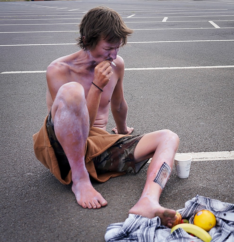 Aaron Abel takes a drag of a cigarette at the Maui High School emergency shelter Wednesday, Aug. 9, 2023, in Kahului, Hawaii. A large fire consumed the town of Lahaina Aug. 8 where Abel said he and others sought refuge in the ocean to escape the flames.