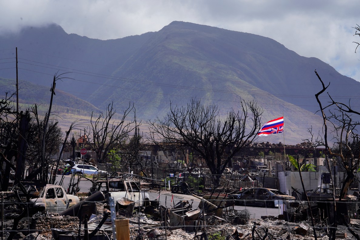 A signal of distress, the upside-down Hawaii State flag flies above the ashes of a destroyed Lahaina neighborhood Thursday, Nov. 9, 2023. Lahaina town was devastated by the Aug. 8. fire. Tourism reopened in West Maui on Nov. 1. (Kevin Fujii/Civil Beat/2023)