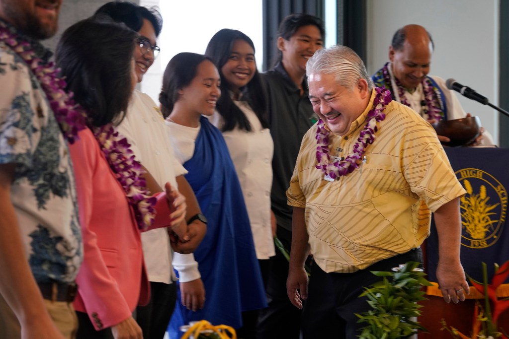 Department of Education Superintendent Keith Hayashi enjoys a light-hearted moment during the blessing of the Waipahu High School Integrated Academy Learning Center  Friday, Dec. 1, 2023, in Waipahu. The center offers students the opportunity to learn trades and skills. (Kevin Fujii/Civil Beat/2023)