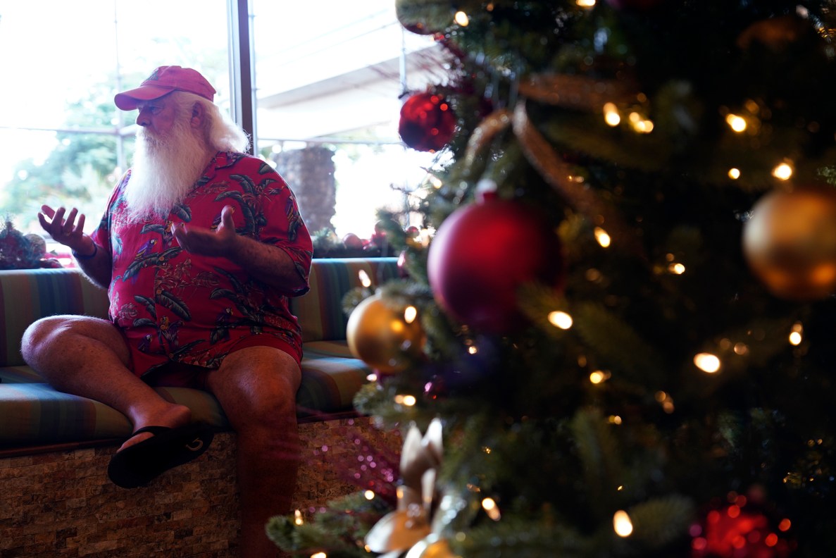 Ron Proctor talks with a Civil Beat reporter at his temporary residence Thursday, Dec. 7, 2023, at the Royal Lahaina Resort in Lahaina. Proctor who has been Santa Claus for almost three decades lost everything in the Aug. 8 fire. (Kevin Fujii/Civil Beat/2023)