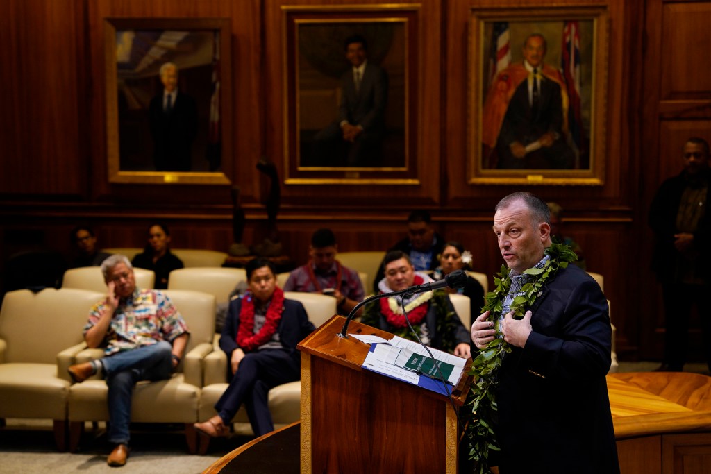 Gov. Josh Green updates the status of the Maui recovery Friday, Dec. 15, 2023, in Honolulu. House Speaker Scott Sakai, from left, Senator Troy Hashimoto and Rep. Tyson Miyake listen. Portraits of governors past line the mauka wall. (Kevin Fujii/Civil Beat/2023)