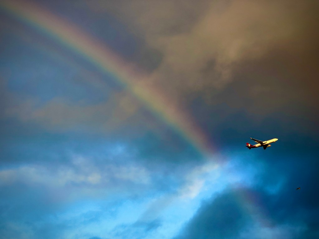 A Hawaiian Airlines passenger jet passes Tuesday, Dec. 19, 2023, a rainbow over Ewa Beach. On Dec. 4 Alaska Airlines announced an acquisition of Hawaiian Airlines for $1.9 billion. (Kevin Fujii/Civil Beat/2023)