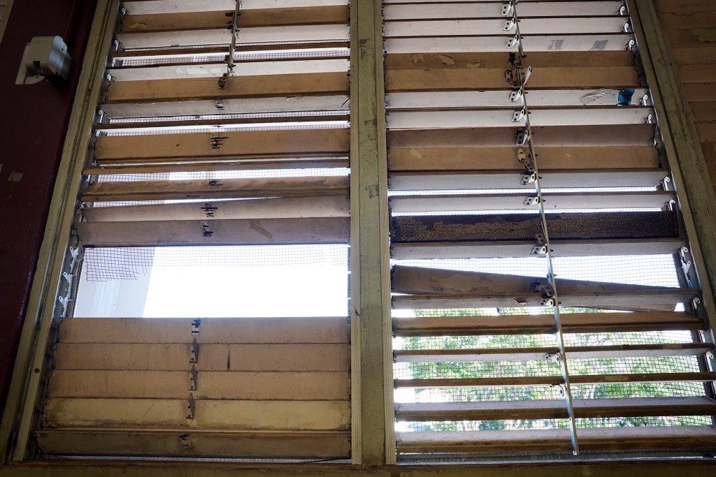 Broken windows of Farrington High School’s Kitamura Gym are photographed Friday, Dec. 29, 2023, in Honolulu. Lack of CIP funding for repairs and renovations have created a safety hazard for students, faculty, staff and visitors. (Kevin Fujii/Civil Beat/2023)