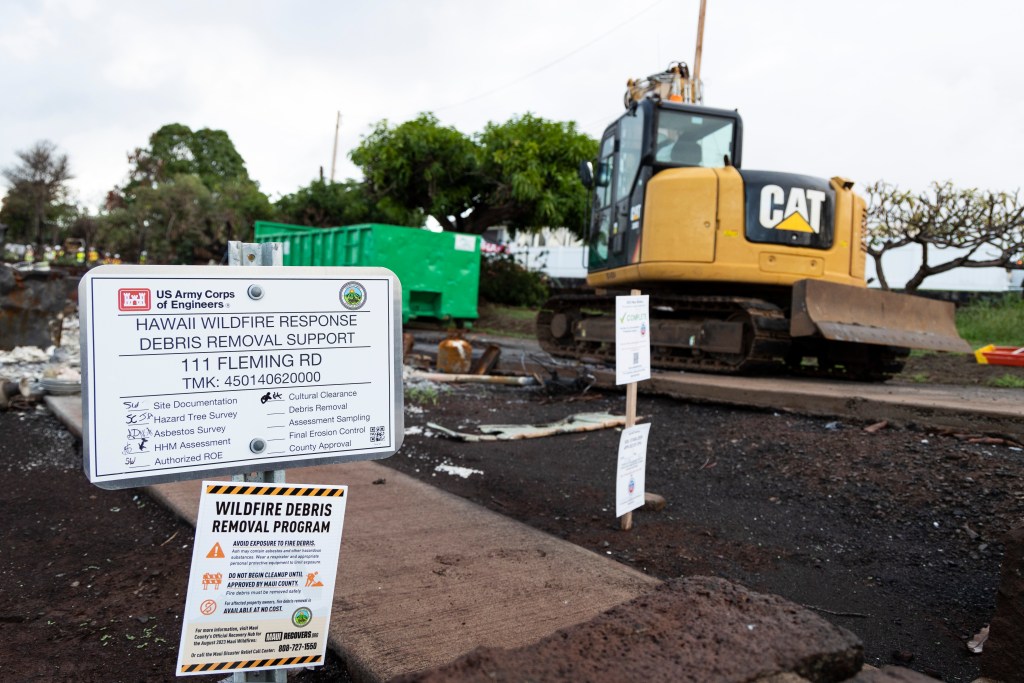 Provided photo USACE sign showing debris removal and Alpha Inc. earthmover in Lahaina from location on Fleming Road in January 2024.