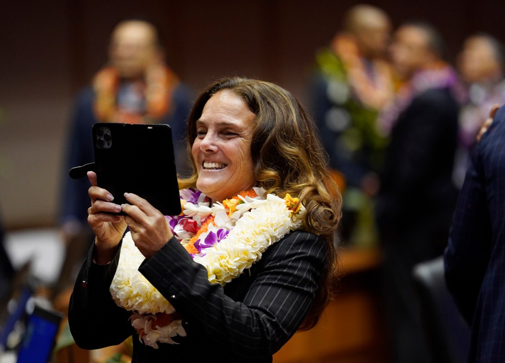 The House of Representatives majority whip Amy Perruso photographs some colleagues before opening the legislative session Wednesday, Jan. 17, 2024, in Honolulu. (Kevin Fujii/Civil Beat/2024)