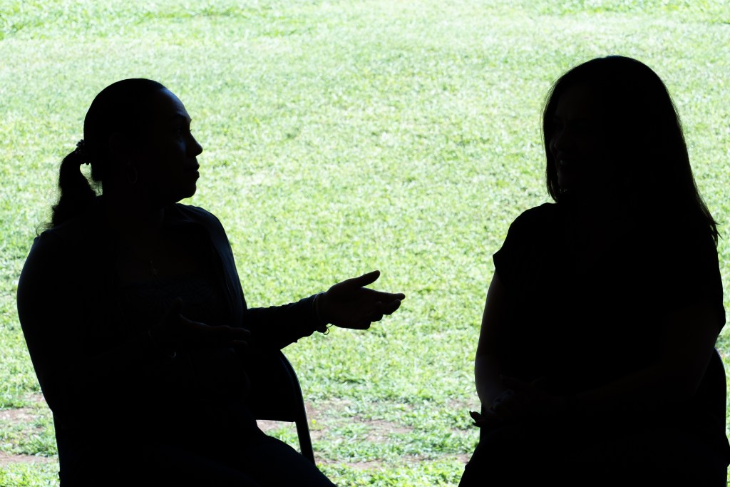 FEMA Interpreter Carolina Davis (brown top) meets with Spanish speaking immigrant Victoria Silva at Lahaina Civic Center, Friday March 1st, 2024. The two became aquainted when Victoria  sought assistance through FEMA following the devastating fires of August 8th. (David Croxford/Civil Beat/2024)