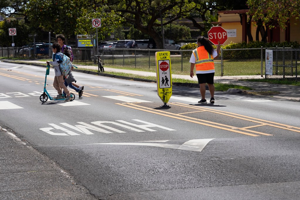 Students cross Papipi Road between speed humps in front of Ewa Beach Elementary School. (Kevin Fujii/Civil Beat/2024)
