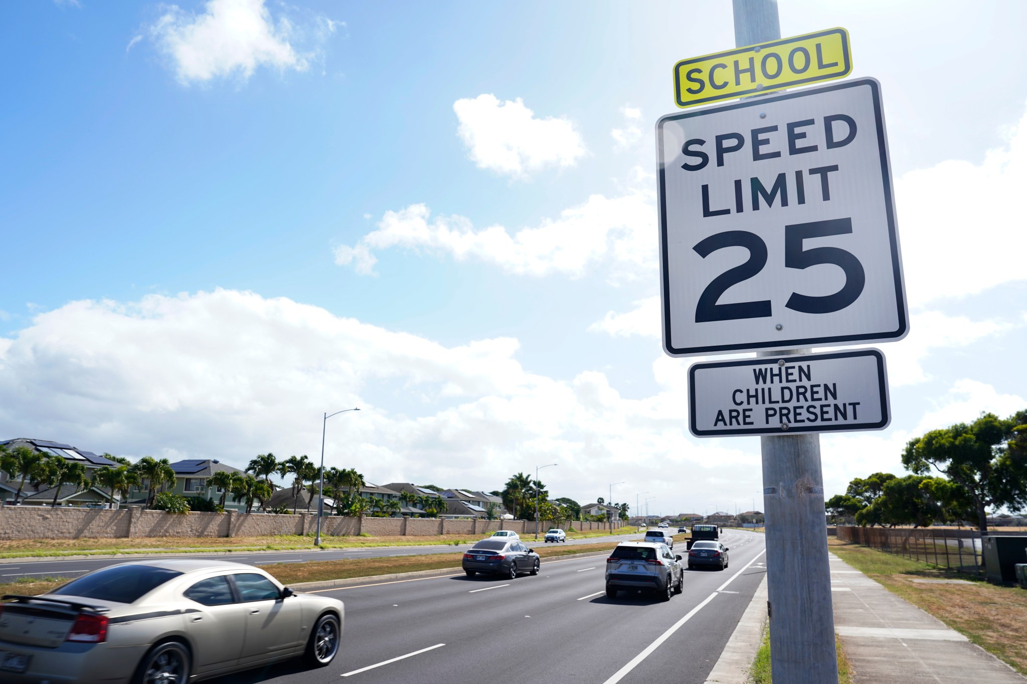Cars drive along Kapolei Parkway in front of Kapolei High School Friday, March 29, 2024. (Kevin Fujii/Civil Beat/2024)