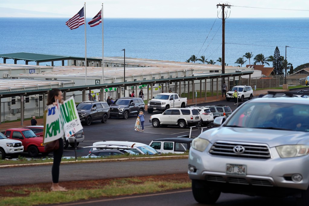 Hugs and signs of support welcome students to the temporary Pulelehua campus of King Kamehameha III Elementary School Monday, April 1, 2024, in Lahaina. Kam 3’s original build was destroyed in the Aug. 8 fire. (Kevin Fujii/Civil Beat/2024)