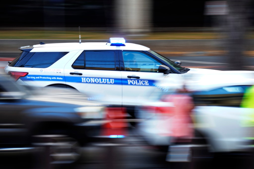A Honolulu Police Department vehicle drives past the Prince Jonah Kūhiō Kalanianaʻole Federal Building and United States Courthouse Thursday, April 4, 2024, in Honolulu. (Kevin Fujii/Civil Beat/2024)