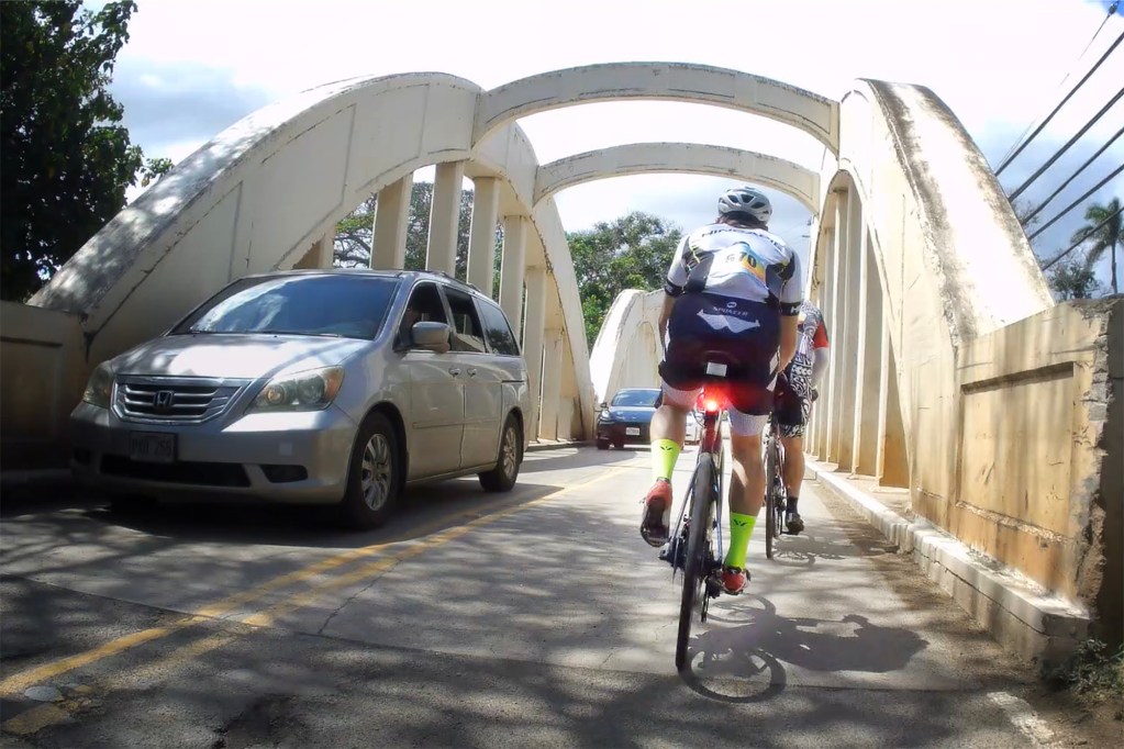 Cyclists ride over the Anahula Stream Bridge, more commonly known as the Rainbow Bridge, Sunday, April 28, 2024, in Haleiwa. More than 700 cyclists participated in Hawaii Bicycle League’s Haleiwa Metric Century and Haleiwa Aloha Fun Ride. Ride distances varied from 5 kilometers or 3.1 miles to 100 KM which covered a little more distance at 62.5 miles. Still photo taken from video. (Kevin Fujii/Civil Beat/2024)