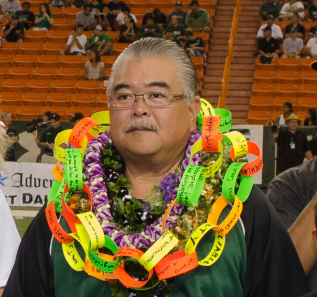 Wesley Yonamine at poses for a photo at Aloha Stadium and draped in leis.