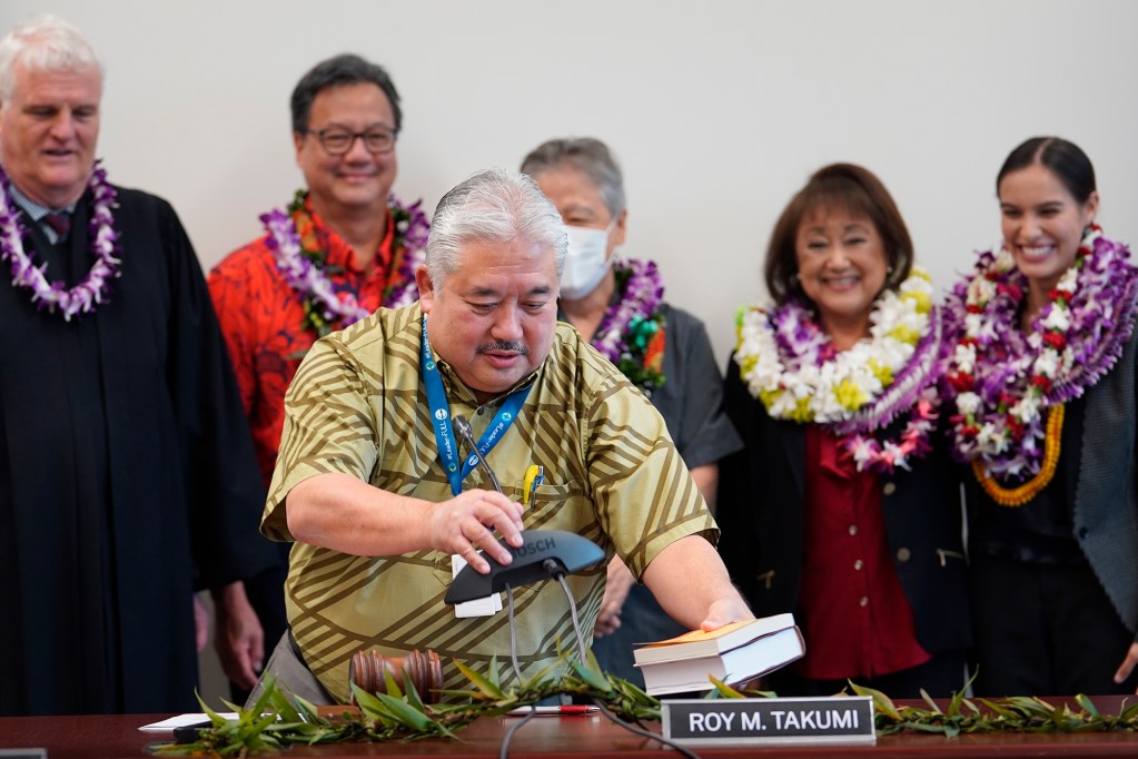A principal’s job never stops. Former Waipahu High School principal turned Department of Education Superintendent Keith Hayashi straightens up before a group photo of newly inducted Board of Education members Thursday, May 9, 2024, in Honolulu. Supreme Court Chief Justice Mark Recketnwald, from left, Wesley Lo, Chair Roy Takumi, Elynne Chung and student representative Kalāheo High School senior Ahryanna McGuirk. (Kevin Fujii/Civil Beat/2024)