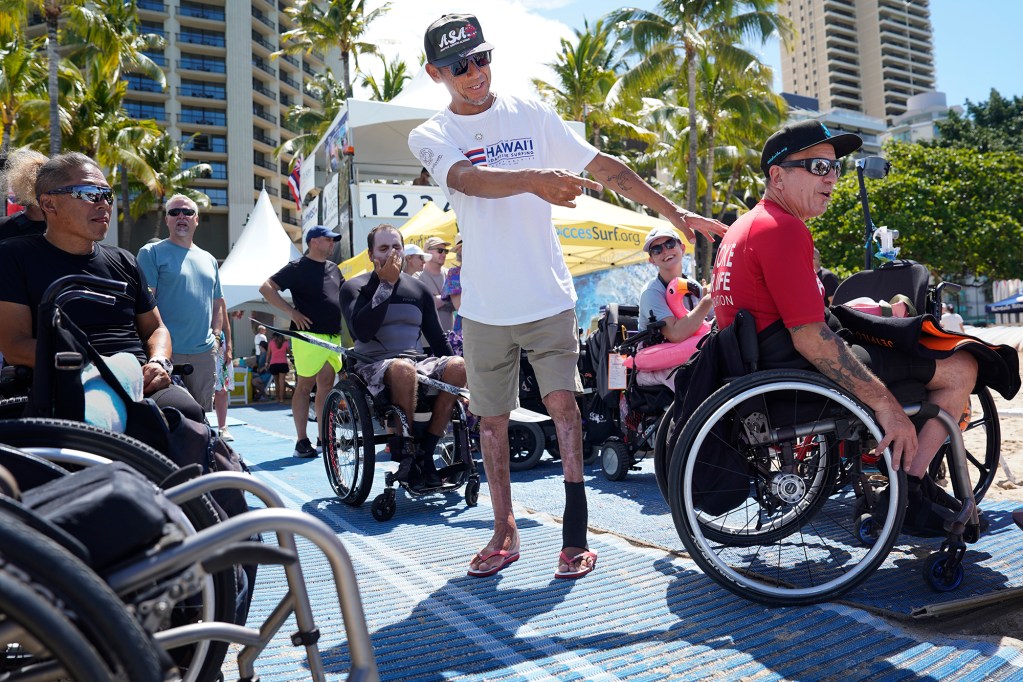 Naomichi Katsukura of Japan, center, jokes with Charles “Chaka” Webb, right, during the 2024 Hawaii Adaptive Surfing Championships Monday, May 13, 2024, in Honolulu. Katsukara competes in the Above Knee Standing division. Webb surfs in the Wave Ski division. (Kevin Fujii/Civil Beat/2024)