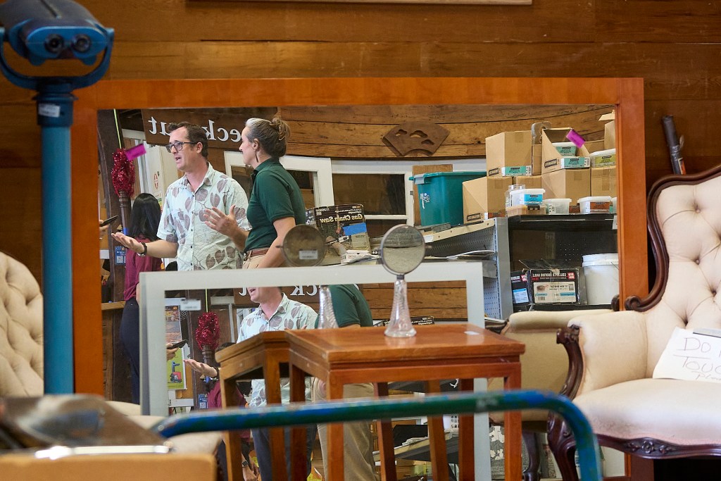 In a warehouse in Kakaako, next to the Waterfront Park is a huge collection of reusable items.  All of them garnered from various deconstruction projects managed by ReUse Hawaii and made available to the public. Reflected in some of the mirrors at the location are Quinn Vittum and Alexis Schultz and photographed May 14th, 2024(David Croxford/Civil Beat/2024)