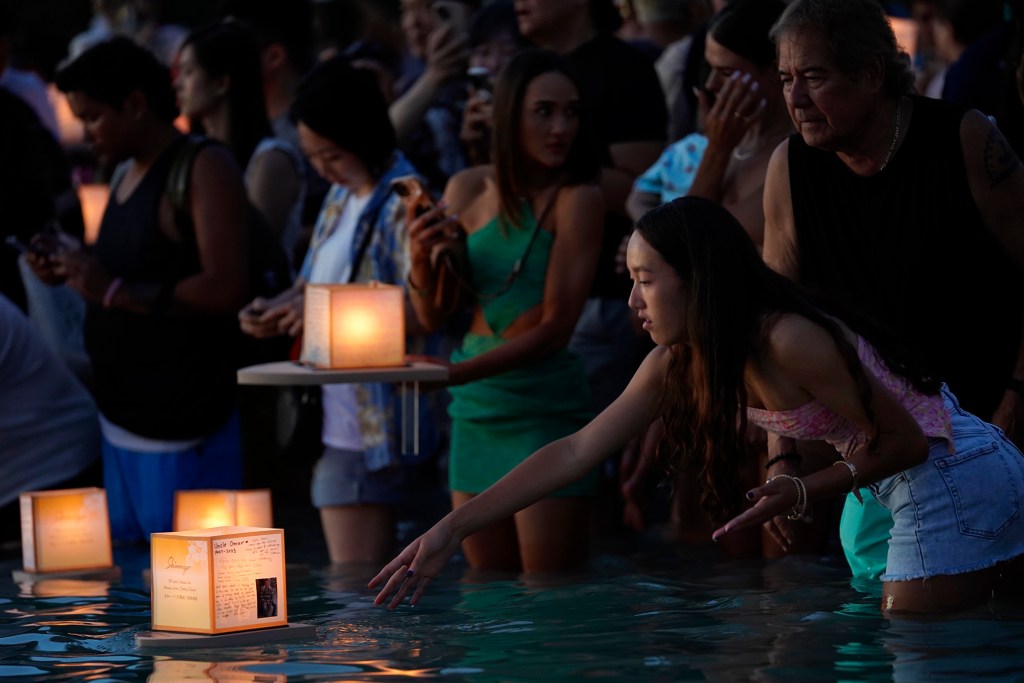 A lantern with messages and a photo is set afloat during the 25th anniversary Shinnyo Lantern Floating Hawaii 2024 Monday, May 27, 2024, at Ala Moana Beach Park in Honolulu. The annual Memorial Day event distributed 6,000 floating lantern kits earlier in the day. (Kevin Fujii/Civil Beat/2024)