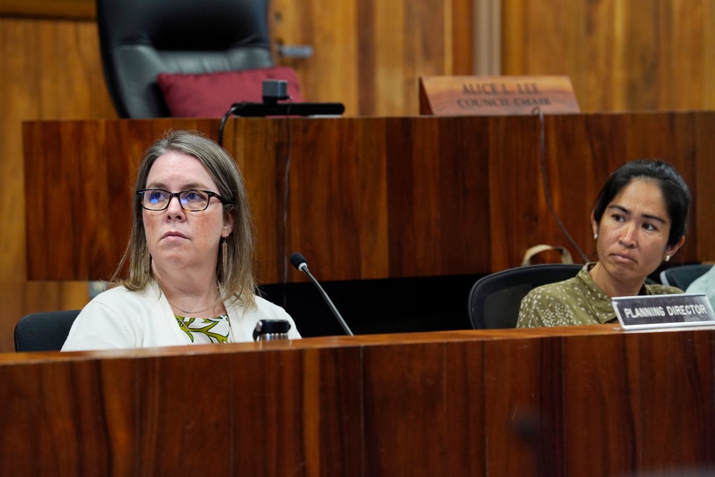 Planning Director Kate Blystone, from left, and Maui Planning Commission Chairperson Kim Thayer look toward a screen with data during a meeting to consider abolishing short-term rentals on Tuesday, June 25, 2024, in Wailuku. (Kevin Fujii/Civil Beat/2024)