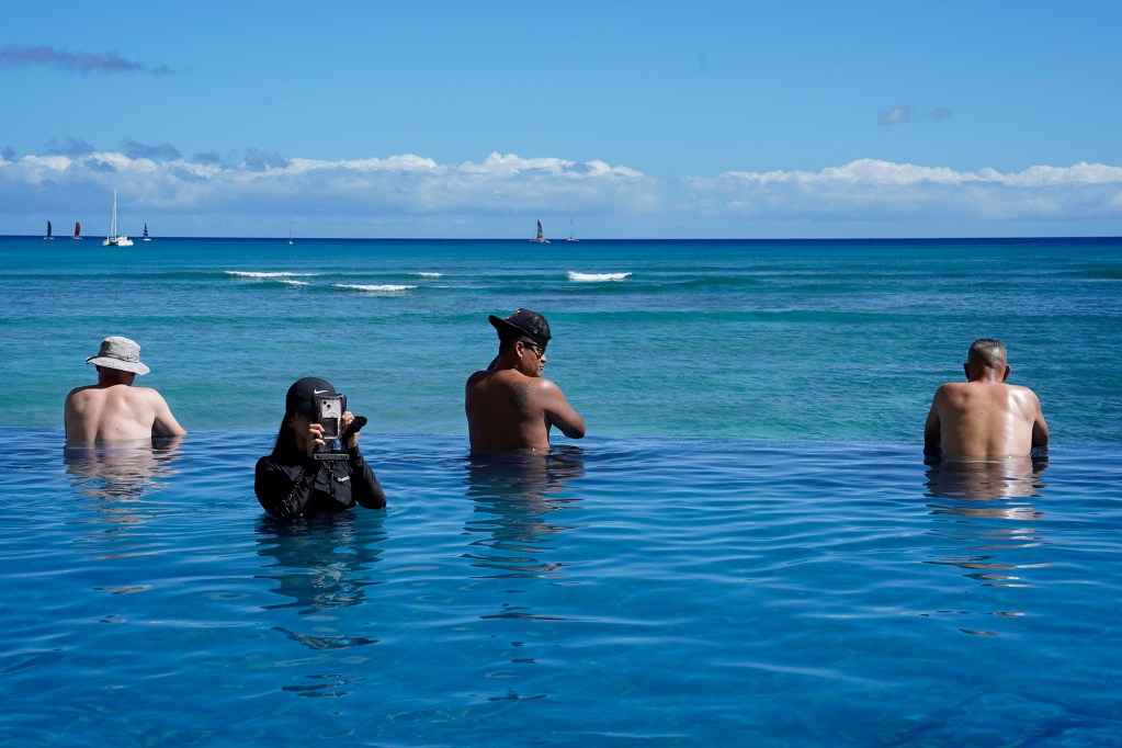 Swimmers enjoy looking toward Populars surf break from the Sheraton Waikiki Infinity Pool on Thursday, June 27, 2024, in Honolulu. (Kevin Fujii/Civil Beat/2024)