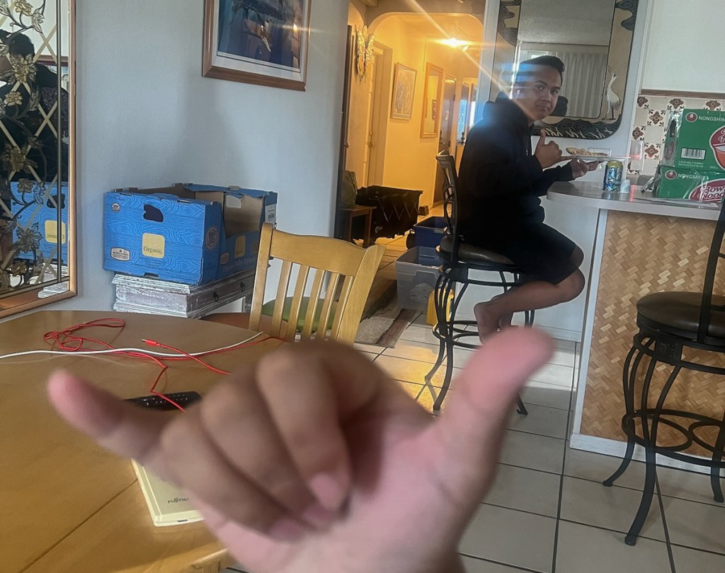 Lahaina fire survivor Zach Ruidas uses a shaka to show how happy he and his twin brother Dylan Ruidas (in the background) are to be provided a condo in Kihei to live in after months of residing in a hotel room. (Zach Ruidas)
