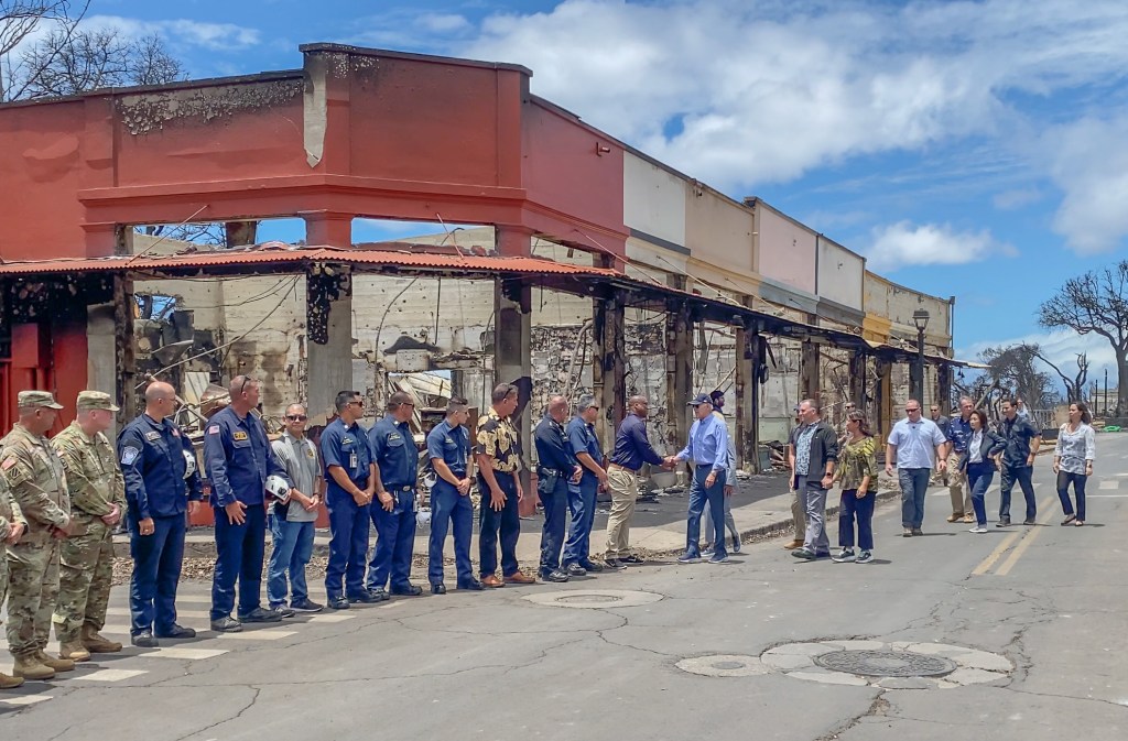 President Joe Biden shakes hands with FEMA's Curtis Brown in front of what used to be Lappert's Ice Cream in a burned building owned by the Furtado family. (Cammy Clark/2023)