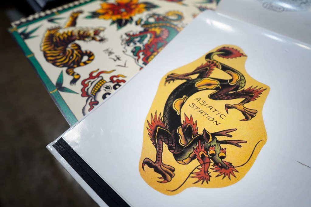 Old Ironside Tattoo’s portfolio includes many of the original Sailor Jerry styles as seen at The Hawaii Tattoo Expo Friday, Aug. 2, 2024, in Honolulu. This style of tattoo is a mix of Asian and local art. Old Ironside Tattoo is Hawaii’s oldest tattooing establishment. Hard Seda re-opened it in 2014.(Kevin Fujii/Civil Beat/2024)