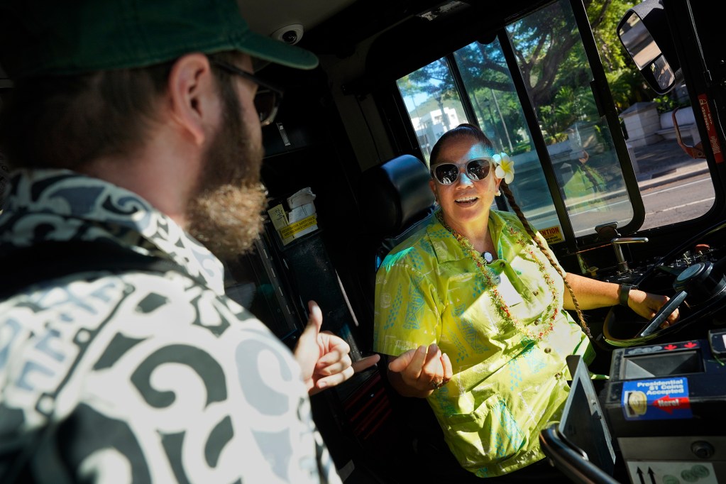 Passenger Reed Mershon says goodbye to The Bus route 18 driver Kathy Paiva after his last ride on this route Thursday, Aug. 15, 2024, in Honolulu. The route will be discontinued. Some regular riders have found a community with each other and the driver. (Kevin Fujii/Civil Beat/2024)