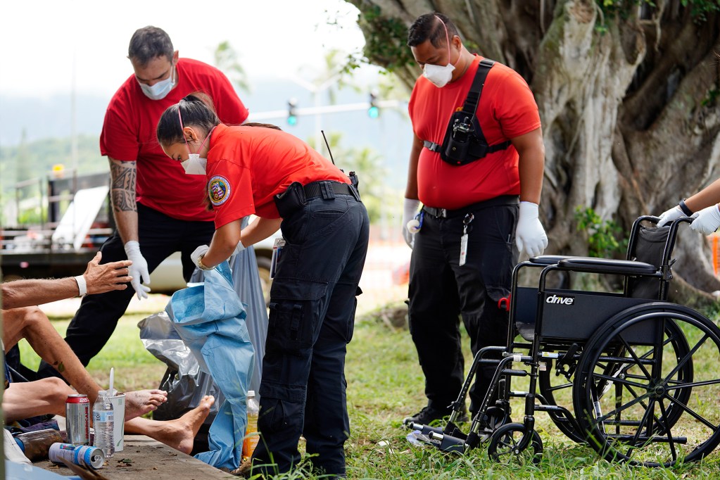 Honolulu C.O.R.E. team including EMT Bethany Nakano helps a homeless patient put on pants outside of Adventist Health Castle hospital Monday, Aug. 19, 2024, in Kaulua. (Kevin Fujii/Civil Beat/2024)