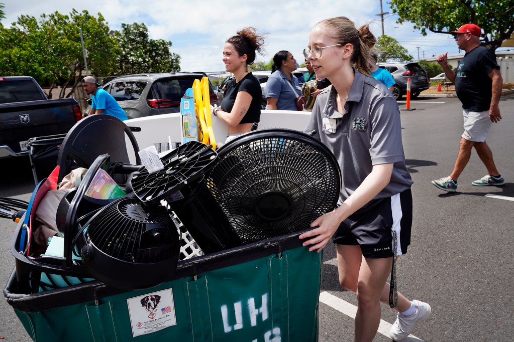 Gina Trent, center of Walnut Creek, California, and Resident Assistant Shannon Pederson help move Trent’s younger sister into Hale Wainani student housing on the University of Hawaii Manoa campus Friday, Aug. 23, 2024, in Honolulu. The dorms were a buzz of activity on the last official day to move in before the semester begins next week. (Kevin Fujii/Civil Beat/2024)
