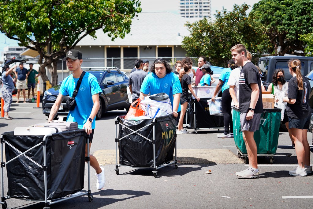 Volunteers push loads of students' personal belongings as they move into University of Hawaii’s Hale Wainani student housing Friday, Aug. 23, 2024, in Honolulu. (Kevin Fujii/Civil Beat/2024)