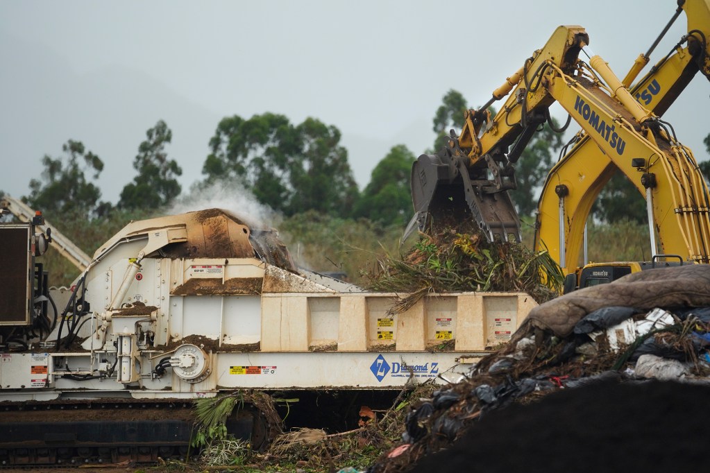 Hawaiian Earth excavators pile sorted green waste during a City and County of Honolulu Refuse Division’s Tour de Trash Wednesday, Aug. 28, 2024, in Wahiawa. The tour follows the journey Oahu residents and visitors rubbish, recyclable items and compostable/green waste take through the collection and disposal process. (Kevin Fujii/Civil Beat/2024)