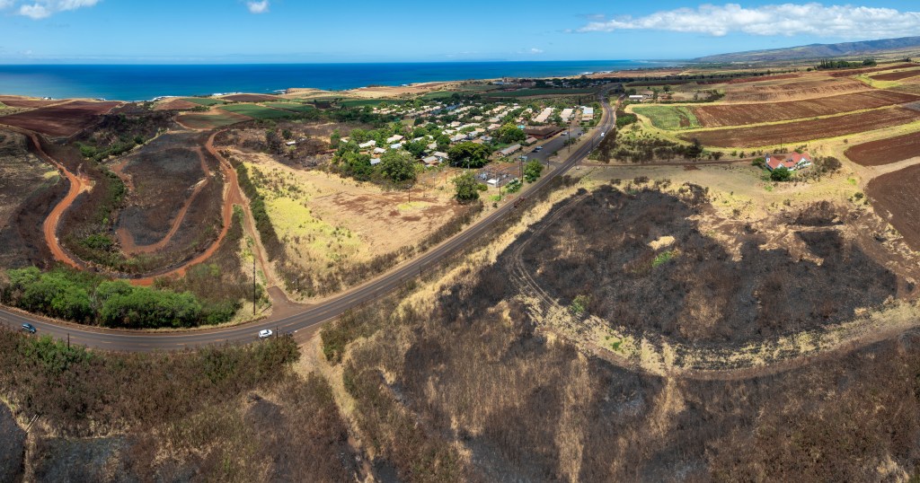 An aerial view of the burn scar left behind after a wildfire scorched over 1000 acres in South Kauai and encroaches on Kaumakani Village.