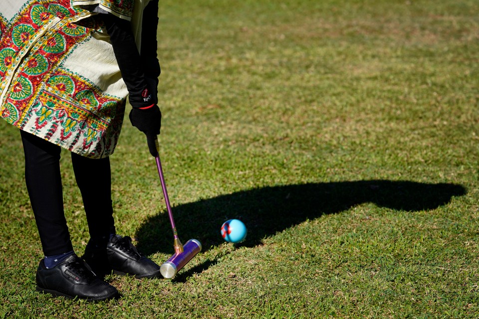 Gateball player Noriko Narita strikes a ball during practice Wednesday, Sept. 4, 2024, at Ala Moana Beach Park in Honolulu. Gateball resembles croquet but requires a different strategy. (Kevin Fujii/Civil Beat/2024)
