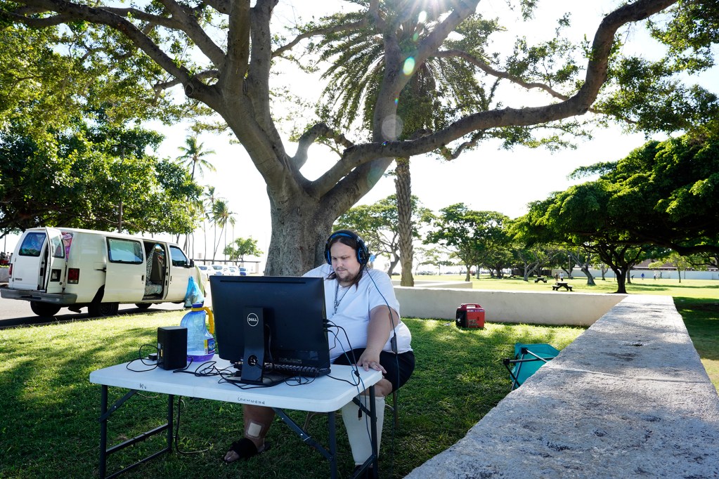 Tristan Powers of Honolulu finds an outdoor office to work on a podcast Wednesday, Sept. 4, 2024, at Ala Moana Beach Park in Honolulu. His podcasts are launched from his X account @Tristan_Powers1. (Kevin Fujii/Civil Beat/2024)