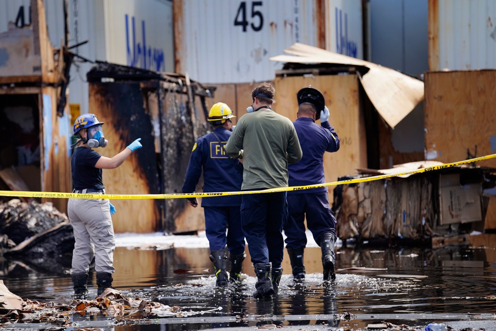 Alcohol, Tobacco and Firearms and Honolulu Fire Department investigators enter a fire scene Thursday, Sept. 5, 2024, at a moving company in Kapolei. Honolulu Police Department also had an investigator on scene. (Kevin Fujii/Civil Beat/2024)