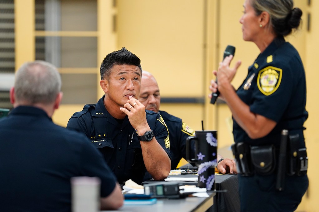 Honolulu Police Department Sergeant Fumikazu Muraoka listens to Major Gail Beckley during a West Oahu Town Hall on public safety Monday, Sept. 16, 2024, at Nanakuli High and Intermediate School in Waianae. State Rep. Darius Kila hosted the town hall with community members City Council member Andria Tupola and law enforcement. (Kevin Fujii/Civil Beat/2024)