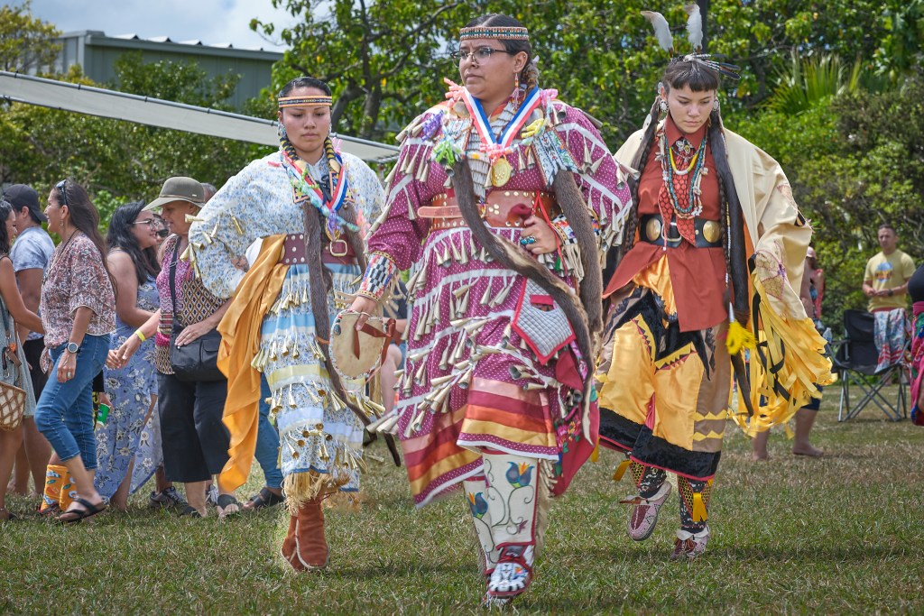 The 48th Annual Honolulu Intertribal Powwow presented by the Ho’opili Tribal council took place at Bishop Museum on September 21 and 22. Head Lady Dancer Tatiana Warren (moon, front, Center) from Red Mesa, Utah dances to celebrate her recent graduation from University programs with her family being greeted for their successes behind her dancing. (David Croxford/Civil Beat/2024