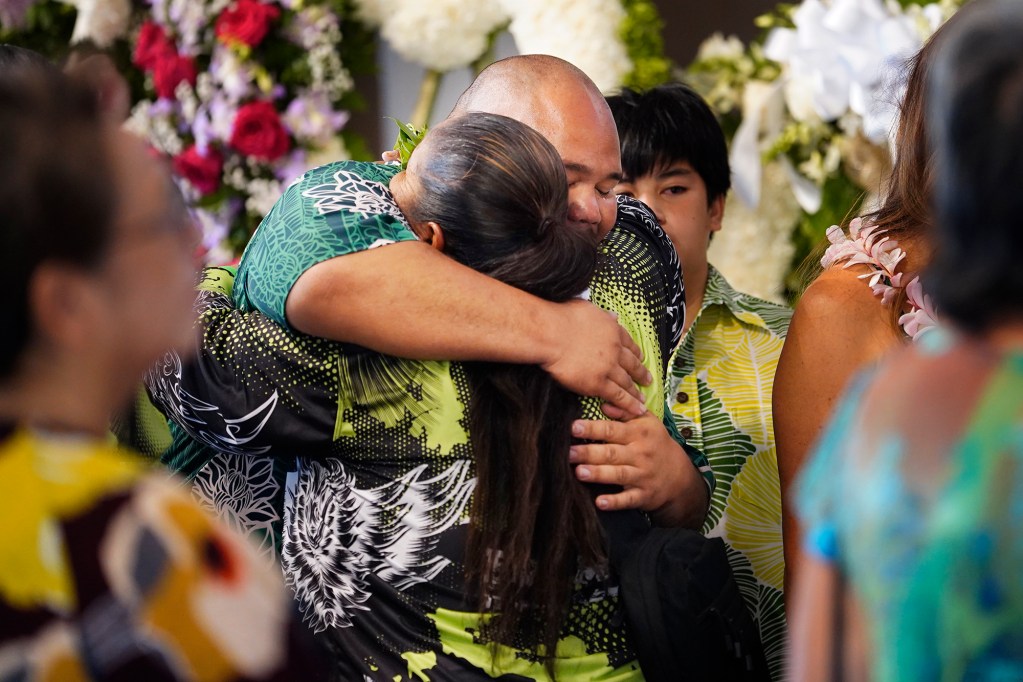 Wyman Keamo hugs family and friends during his girlfriend Courtney Raymond-Arakaki’s memorial service Sunday, Sept. 22, 2024, in Honolulu. Raymond-Arakaki, 34, was killed in an ongoing dispute between neighbors in Waianae. (Kevin Fujii/Civil Beat/2024)