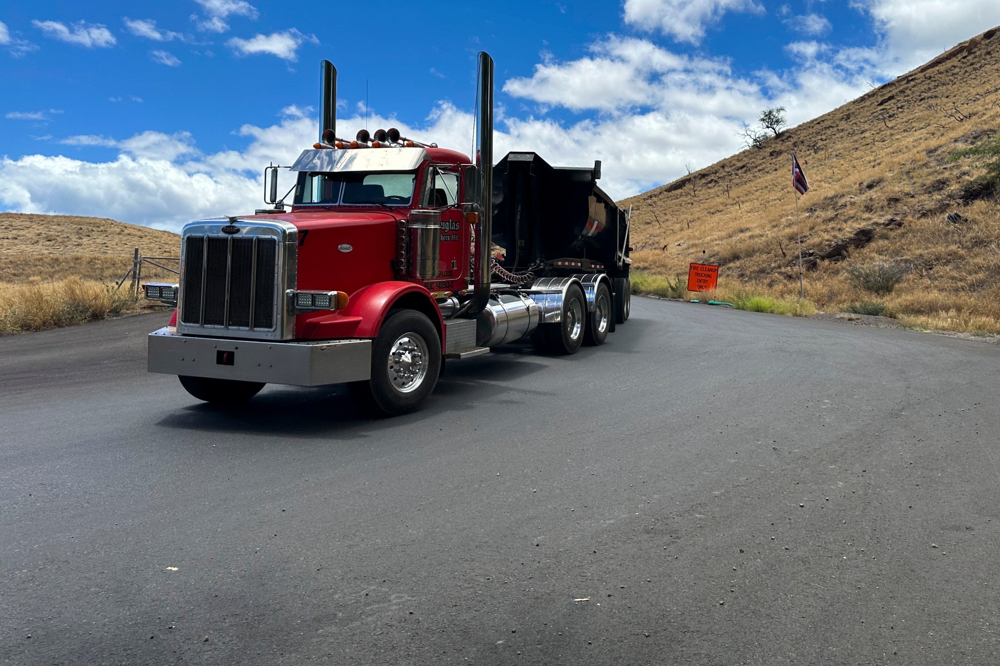 A truck exits from a temporary dump site in Lahaina, Hawaii on Thursday, July 18, 2024, where debris from last year's deadly fire is being stored. (AP Photo/Jennifer Sinco Kelleher)