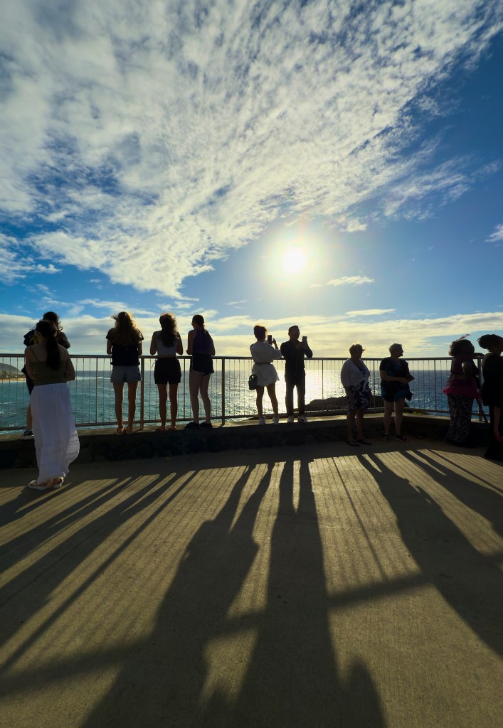 Shadow lines created by the eclipsing sun and tourists at the Halona Blowhole photographed on October 2, 2024.  Bus tourists arrive at the Halona Blowhole to discover the partial Solar eclipse in the final phases of its existence.(David Croxford/Civil Beat/2024)