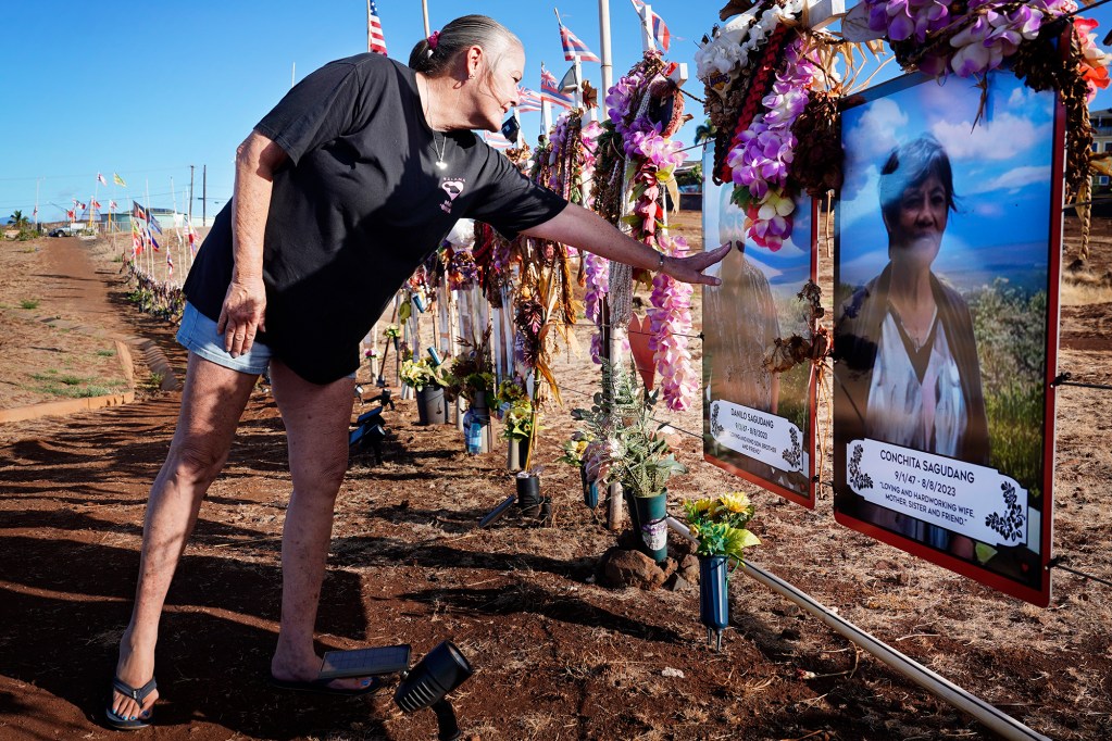 Susie Richter places a kiss on her friend and co-worker Danilo Sagudang after saying, “I love you, Danilo,” at the Lahaina memorial Wednesday, Oct. 2, 2024, in Lahaina. Danilo and his mother Conchita Sagudang were both killed in the Aug. 8, 2023, fire. (Kevin Fujii/Civil Beat/2024)