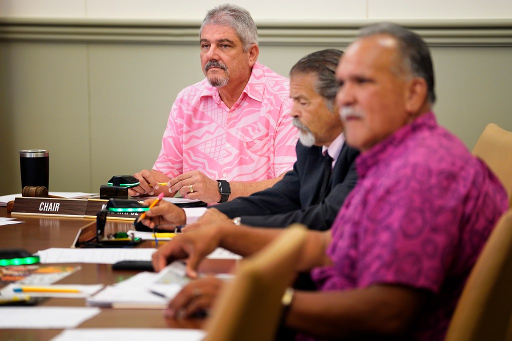 Kauai Council Chair Mel Rapozo listens to those being honored with a proclamation Wednesday, Oct. 9, 2024, in Lihue. Council members Bill DeCosta, middle, and Bernard Carvalho, Jr., look on. (Kevin Fujii/Civil Beat/2024)