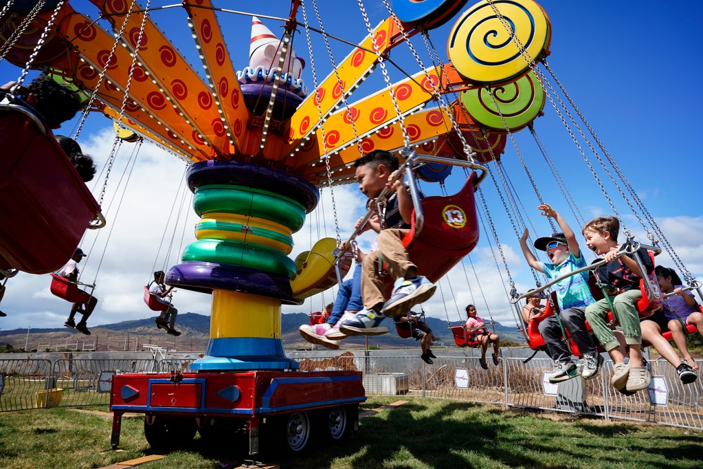 Keiki enjoy a carnival ride at the Aloun Farms 22nd Annual Pumpkin Festival Sunday, Oct. 13, 2024, in Kapolei. The festival is open during the remaining weekends of October. (Kevin Fujii/Civil Beat/2024)